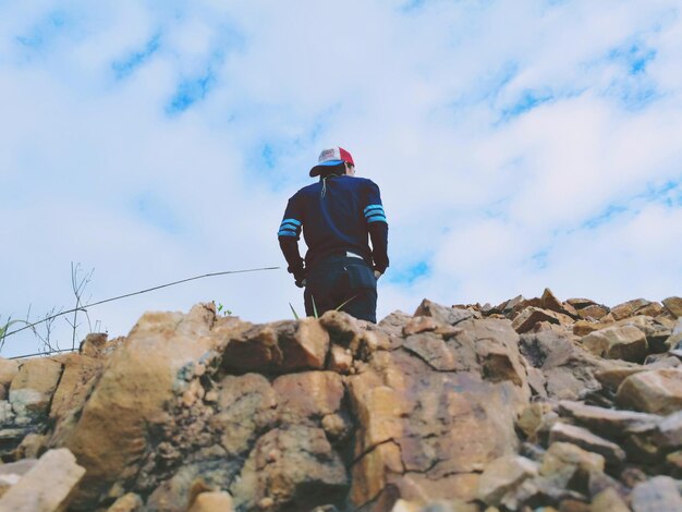 Rear view of man sitting on rock