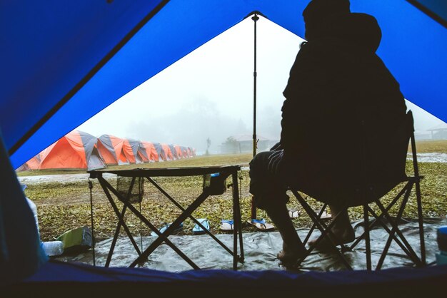 Foto vista posteriore di un uomo seduto in tenda contro il cielo