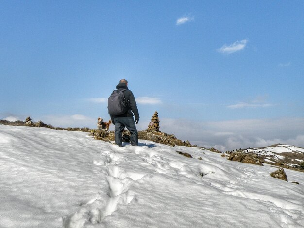 Rear view of man on snow against sky