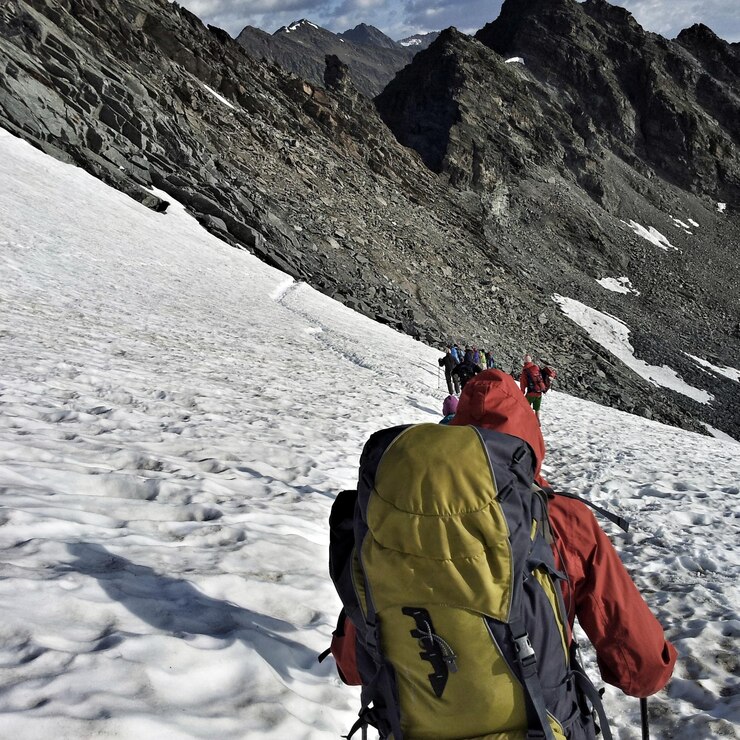 Photo rear view of man on snowcapped mountain against sky