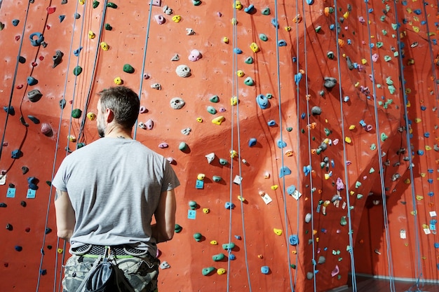 Photo rear view of man standing against climbing wall