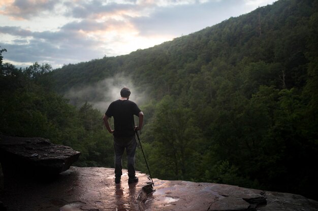 Photo rear view of man standing against mountains