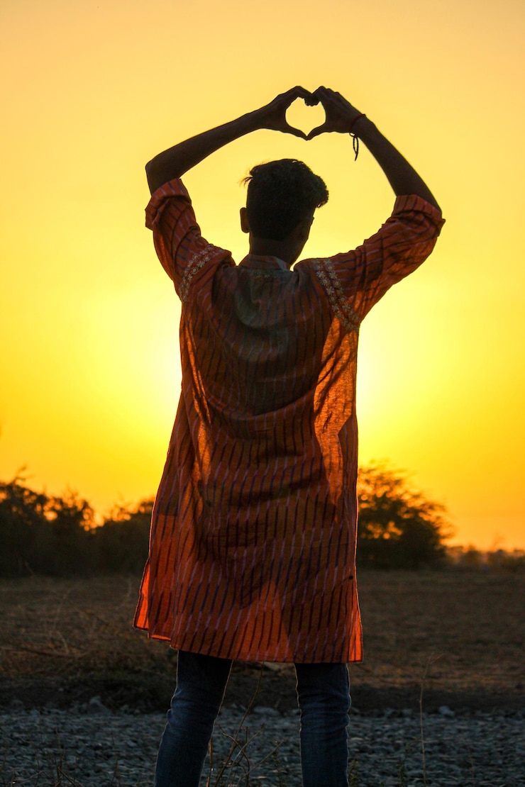 फोटो rear view of man standing against orange sky