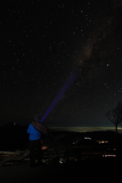 Foto la vista posteriore dell'uomo in piedi contro il campo stellare di notte la via lattea