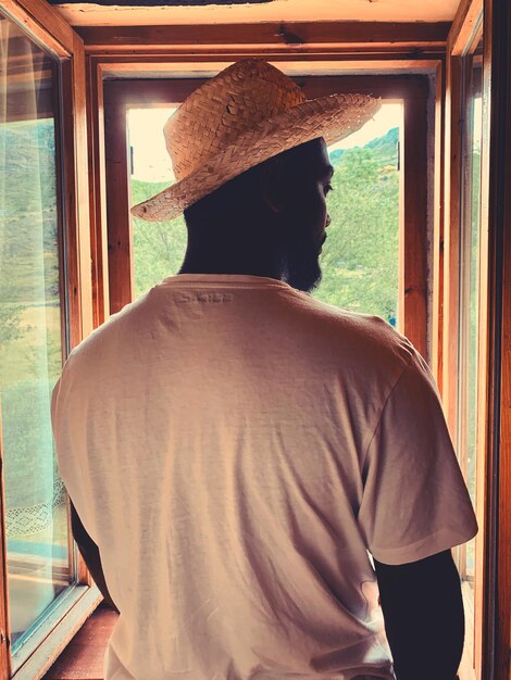 Photo rear view of man standing against window