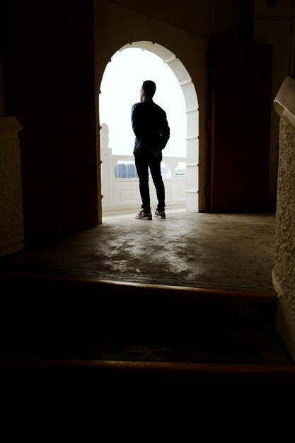 Foto vista posteriore di un uomo in piedi all'arco