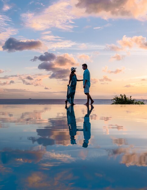 Photo rear view of man standing at beach against sky during sunset