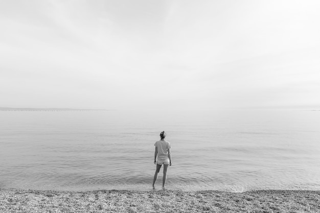 하늘 을 배경 으로 해변 에 서 있는 사람 의 뒷면