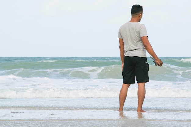 浜辺に立っている男の後ろの景色