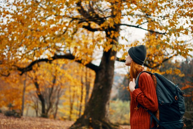 Foto vista posteriore di un uomo in piedi vicino alle foglie durante l'autunno