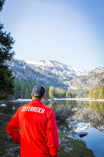 Rear view of man standing by mountain against sky