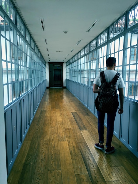 Photo rear view of man standing in corridor