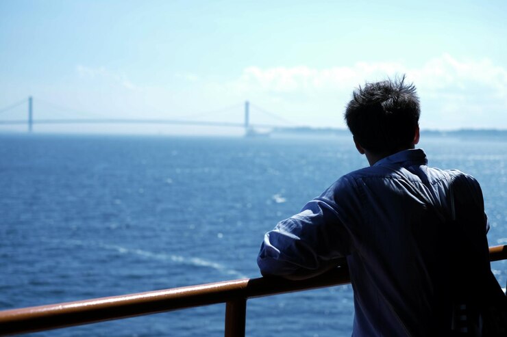 Photo フェリーに立っている男の後ろの景色
