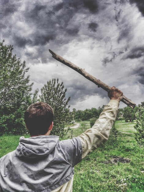 Foto vista posteriore di un uomo in piedi sul campo contro il cielo