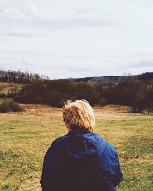 Photo rear view of man standing on field against sky