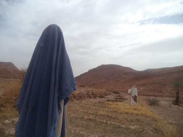 Foto vista posteriore di un uomo in piedi sul campo contro il cielo