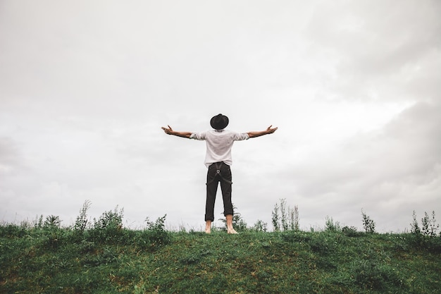 rear view of man standing on field against sky