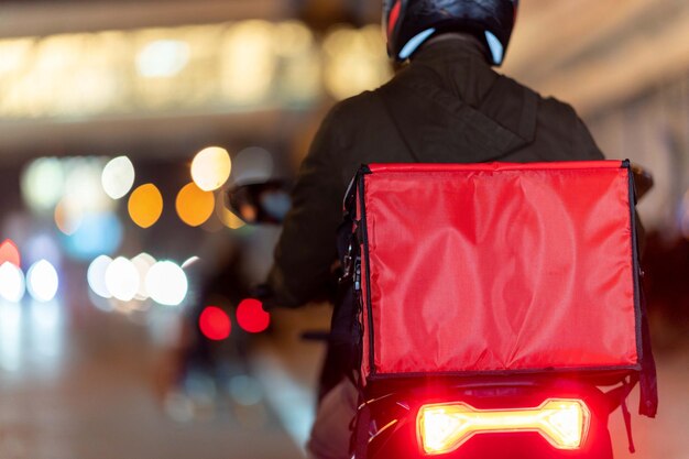 Rear view of man standing on illuminated street