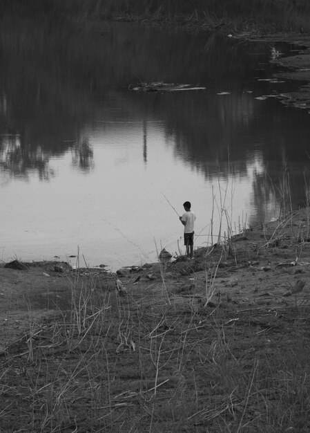 Foto vista posteriore di un uomo in piedi nel lago