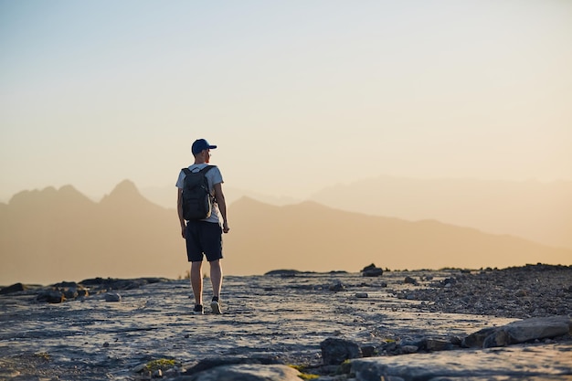 Photo rear view of man standing on land against sky