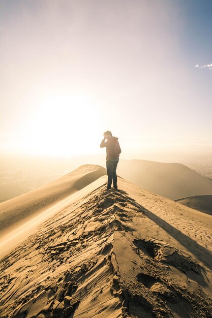 Rear view of man standing on land against sky