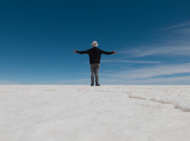 Photo rear view of man standing on landscape against sky