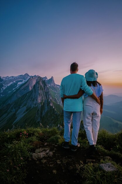 Photo rear view of man standing on mountain against sky during sunset