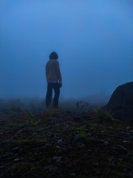 Photo rear view of man standing on mountain against sky