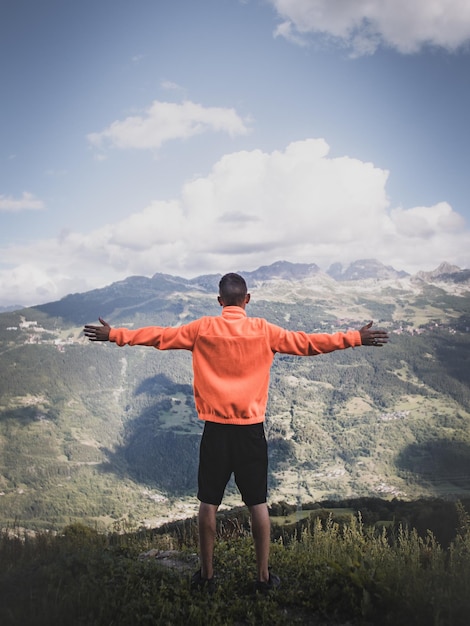 Photo rear view of man standing on mountain against sky