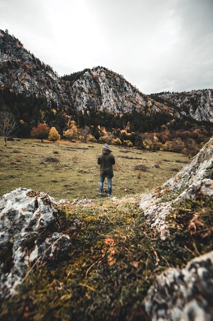 Foto vista posteriore di un uomo in piedi su una montagna contro il cielo