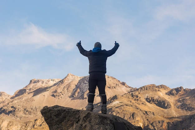 空の向こうの山の上に立っている男の後ろの景色