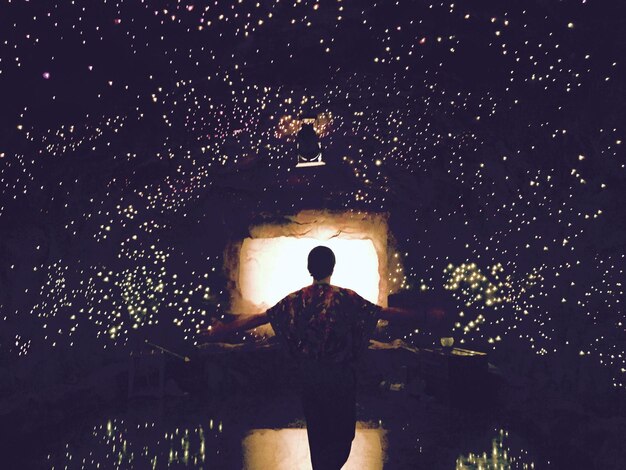 Photo rear view of man standing at night