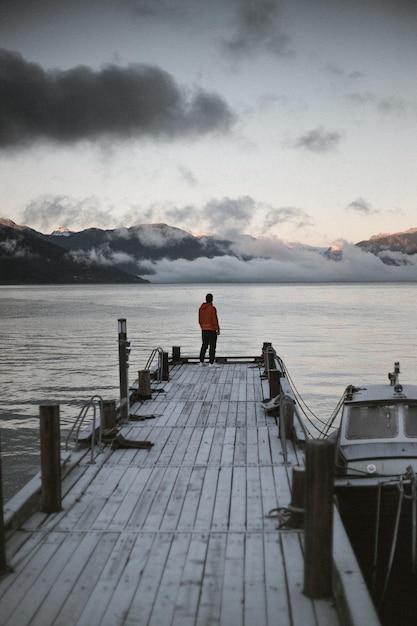 rear view of man standing on pier over sea against sky