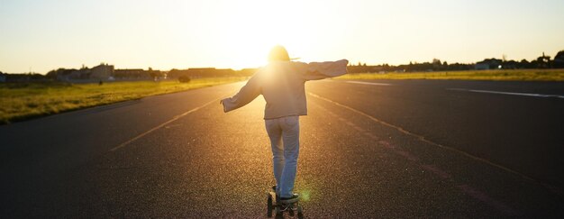 Foto vista posteriore di un uomo in piedi sulla strada contro il cielo durante il tramonto