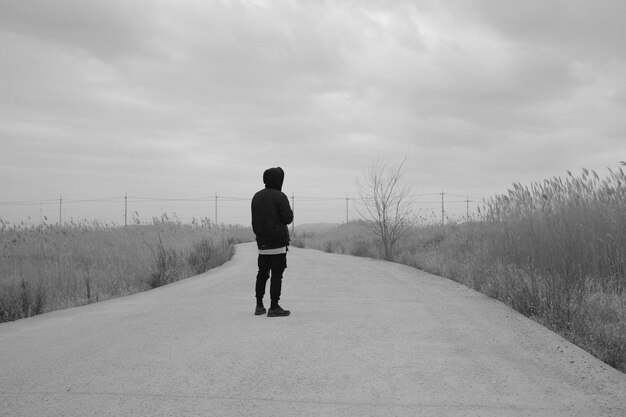 Foto vista posteriore di un uomo in piedi sulla strada contro il cielo