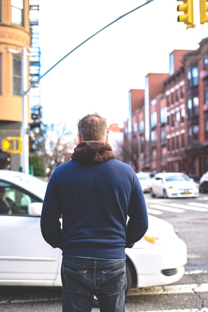 Photo rear view of man standing on road in city