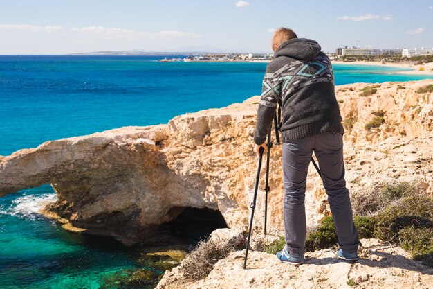 Rear view of man standing on rock by sea