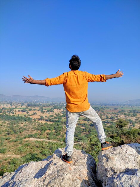 Rear view of man standing on rock