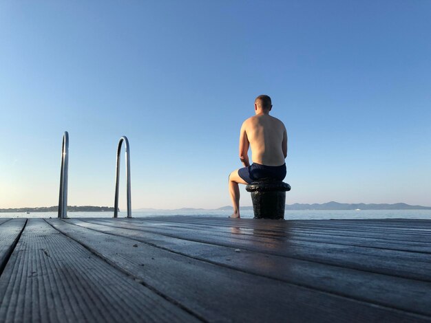 Foto vista posteriore di un uomo in piedi in mare