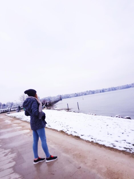 Rear view of man standing on snow covered landscape