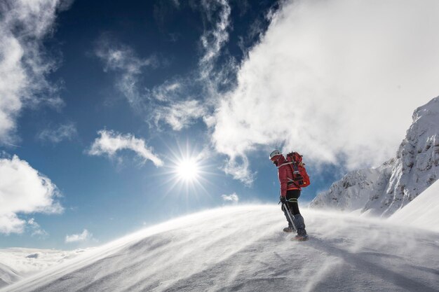 Photo rear view of man standing on snow covered mountain