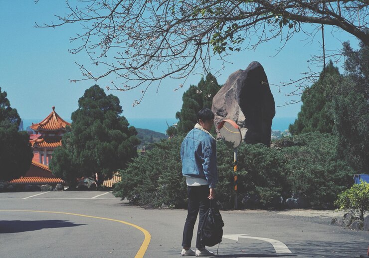 Photo 街の通りに立っている男の後ろの景色