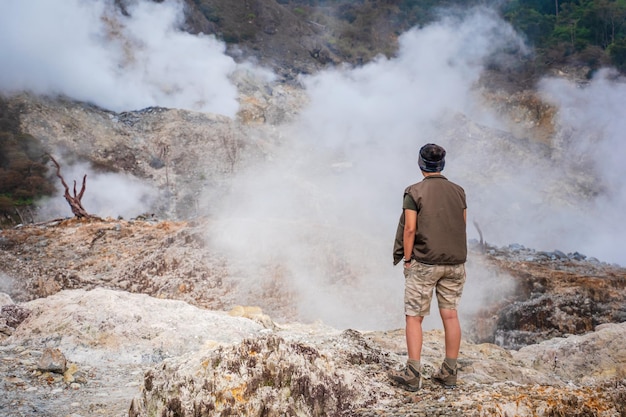 Photo rear view of man standing on volcanic landscape