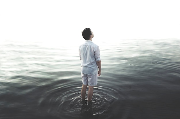 Photo rear view of man standing in water