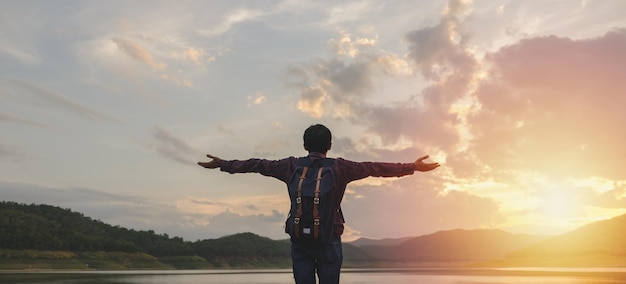 Photo rear view of man standing with arms outstretched against sky