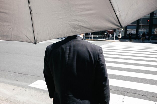 Rear view of man standing on zebra crossing