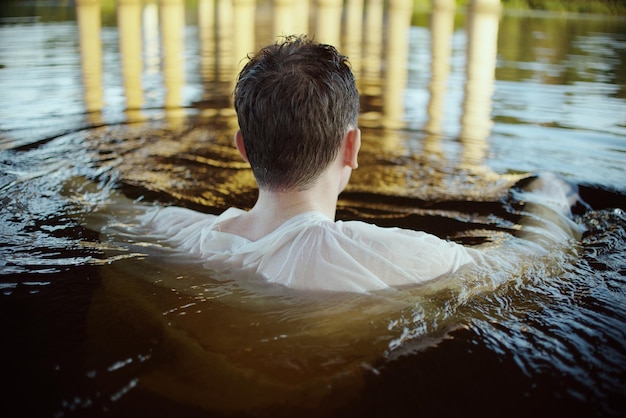 Photo rear view of man swimming in lake