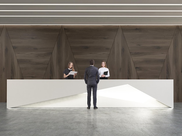 Rear view of man talking to receptionists in room with dark wood walls