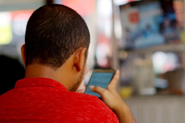 Rear view of man using mobile phone