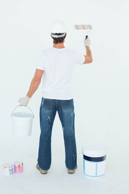 Rear view of man using paint roller